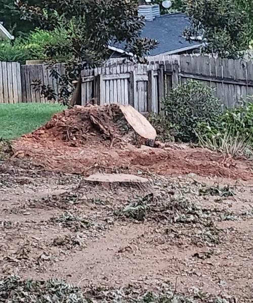 A pile of dirt next to a fence