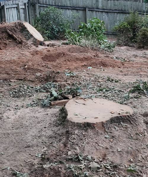 A pile of dirt next to a wooden fence