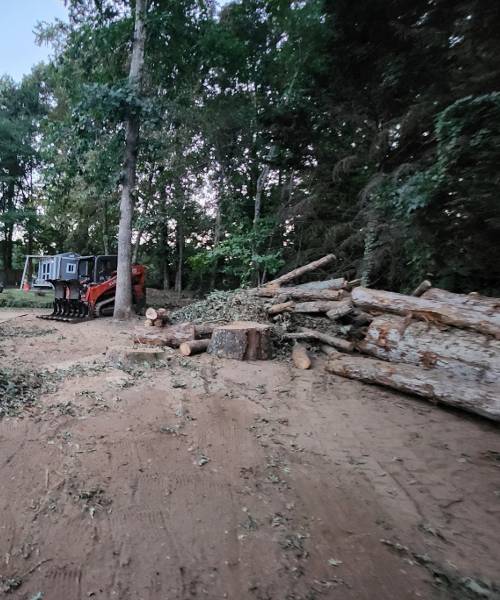 A truck is parked next to a pile of logs