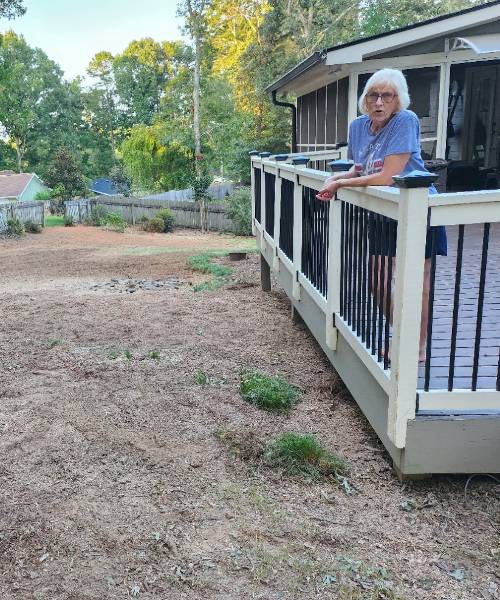 A woman standing on a porch next to a house